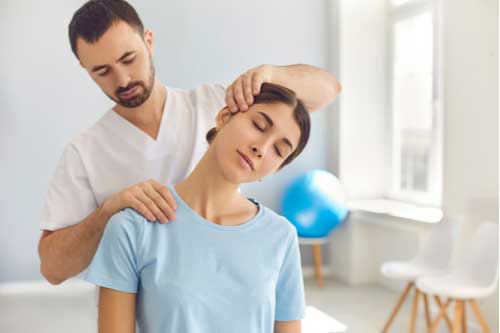 Physical therapist massages woman’s neck Fort Myers whiplash treatment