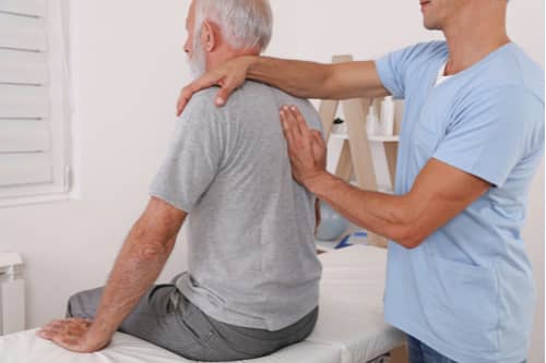 Lehigh Acres back injury treatment, chiropractor treating senior man