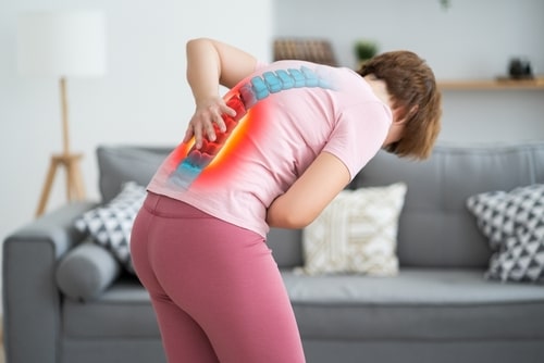 Boca Raton herniated disc treatment concept, woman with back pain at home