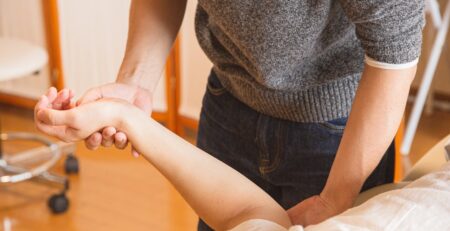 Chiropractor Massaging Hand of Patient