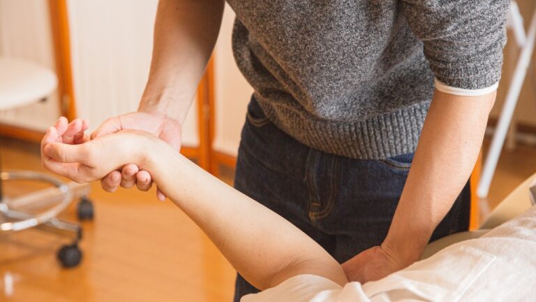 Chiropractor Massaging Hand of Patient